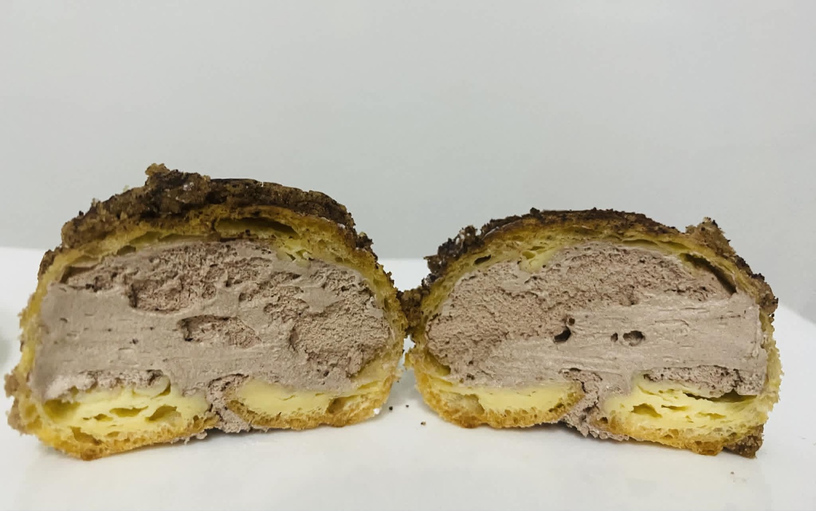 Chocolate cream puff cut open to show its filling